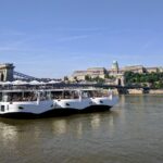 Sightseeing cruise boat sailing on the Danube River in Budapest with views of historic buildings