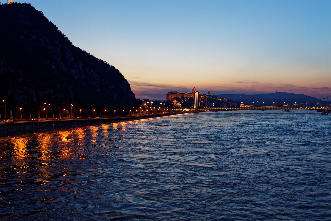 Wide panoramic view of Budapest skyline from the Danube River with Parliament and bridges visible
