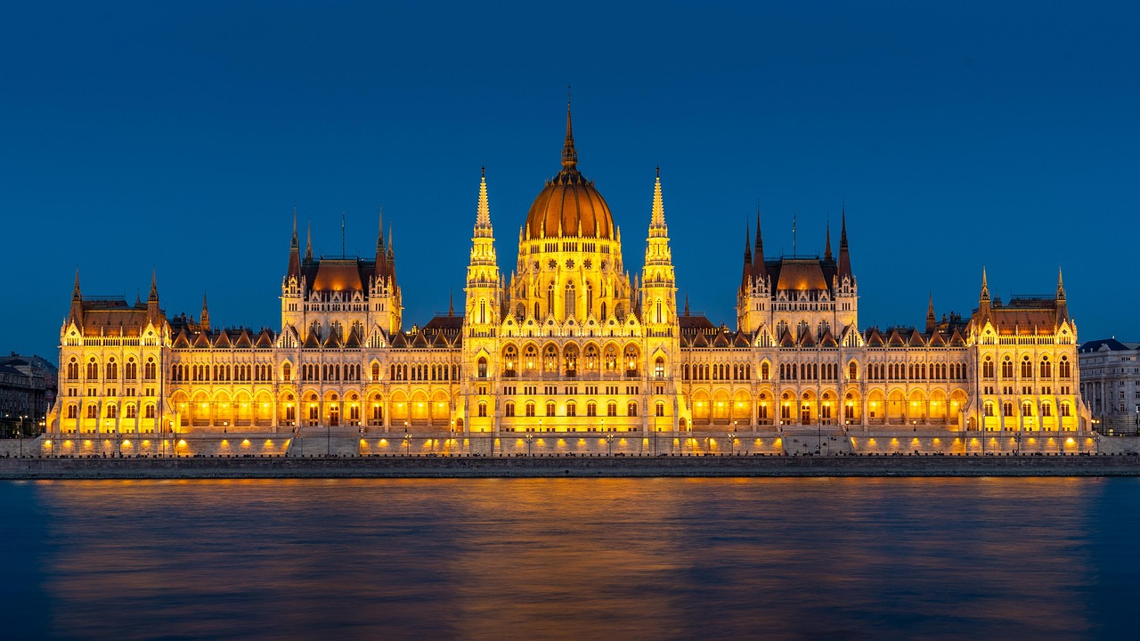 The Hungarian Parliament Building brightly illuminated at night as seen from the Danube River
