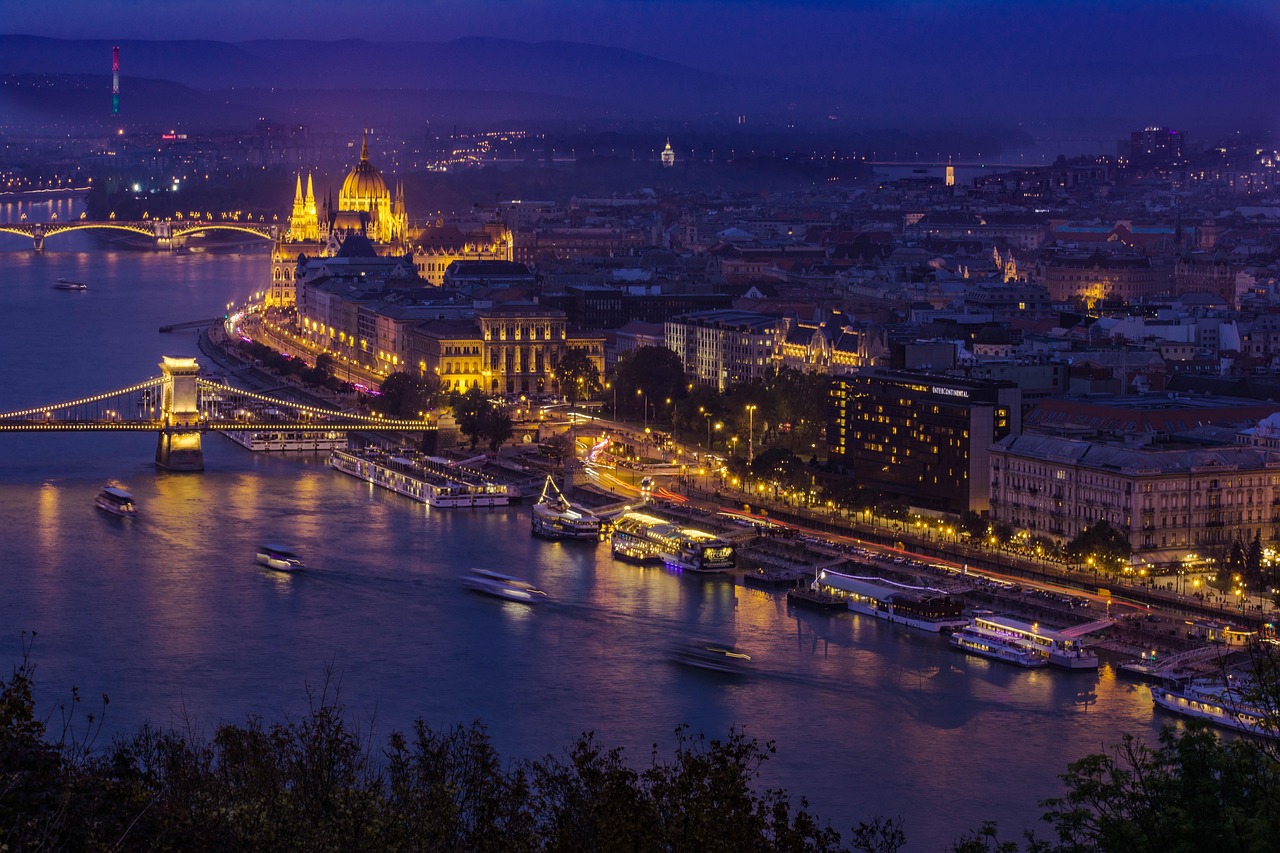 Budapest city skyline bathed in golden sunset light with the Danube River in the foreground