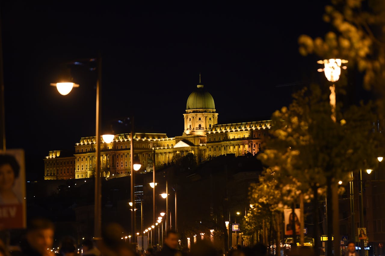 Buda Castle on the hill illuminated with warm lights at night in Budapest