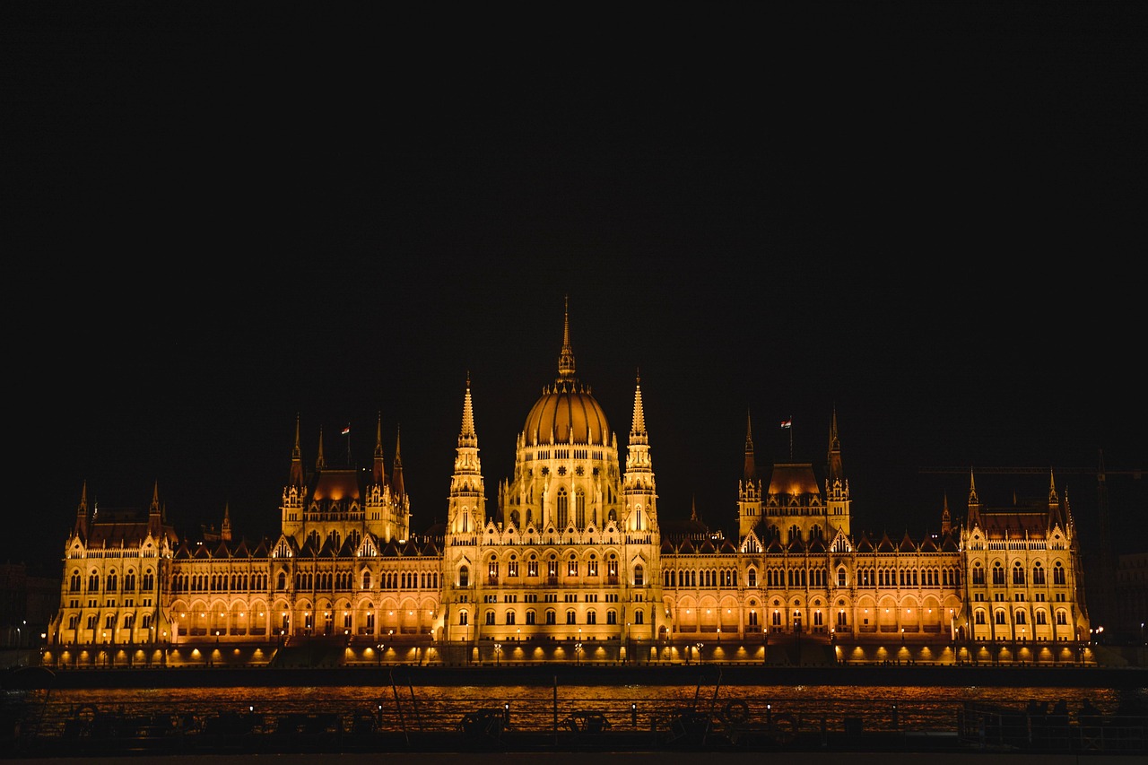 Wide panoramic view of Budapest illuminated at night from across the Danube River