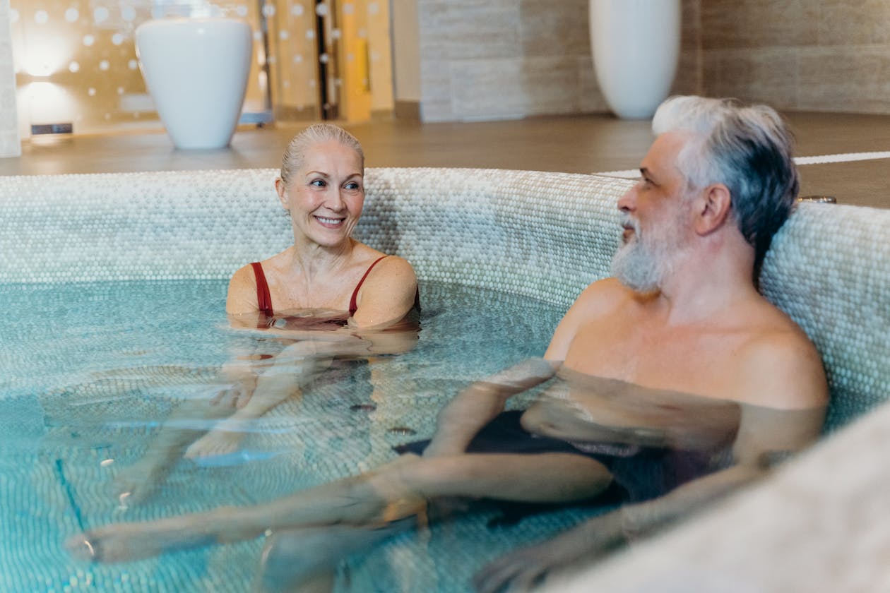 Senior couple smiling and relaxing together in an indoor thermal spa pool