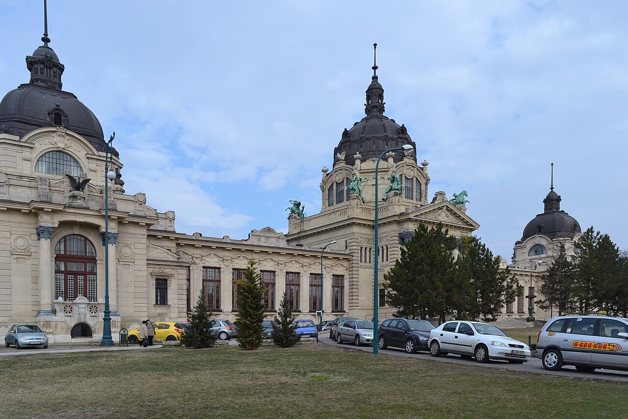 People bathing in the outdoor thermal pool at Széchenyi with steam rising