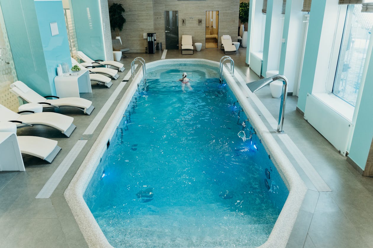 Bright indoor spa pool with lounge chairs creating a calm atmosphere