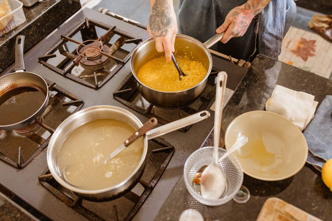 A professional chef stirring ingredients on a stove in a modern kitchen