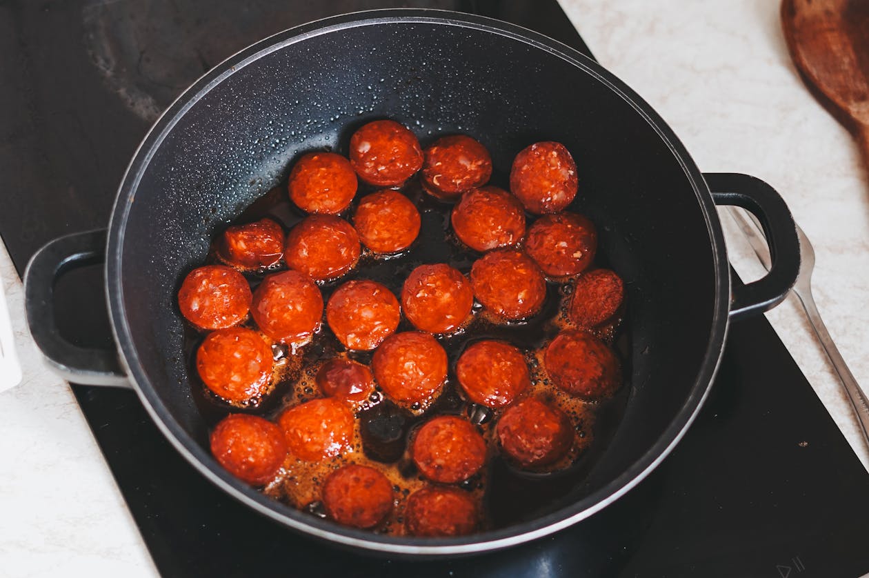 Slices of Hungarian sausages frying in a pan
