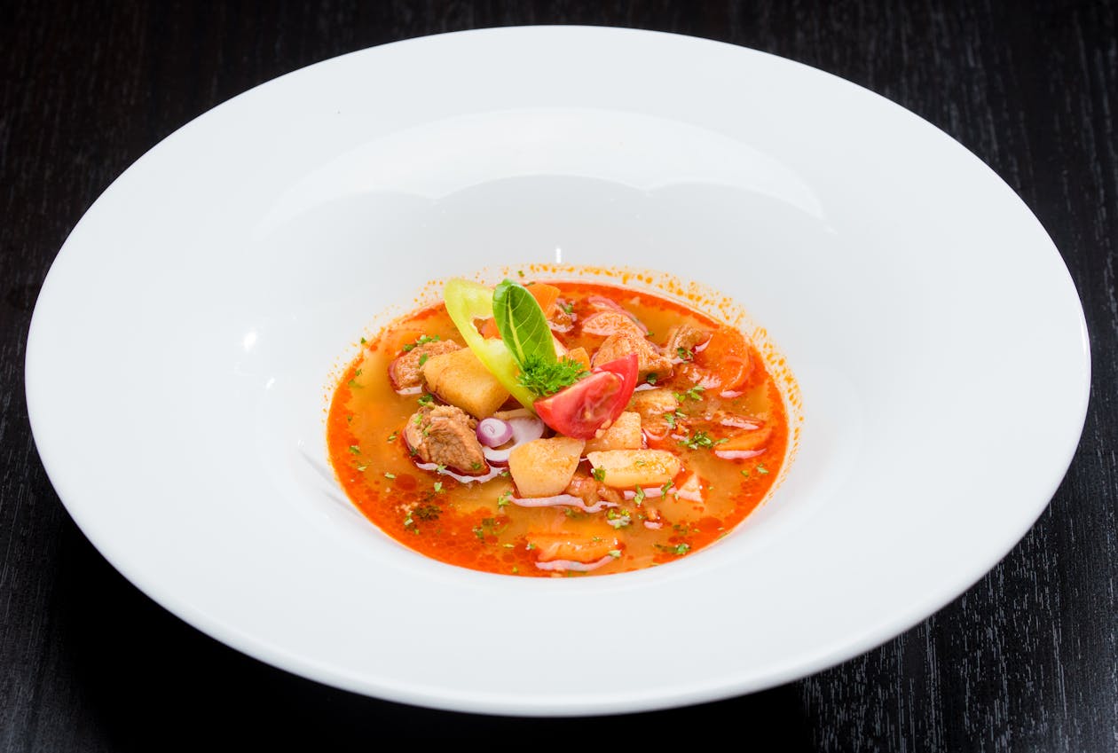 Close-up of a tomato and meat soup in a white bowl
