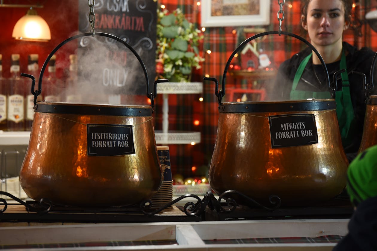 Copper pots of mulled wine steaming at a market stall in Hungary
