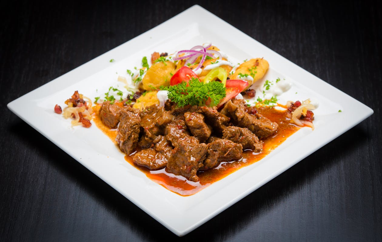 A savory beef stew served with colorful vegetables on a plate