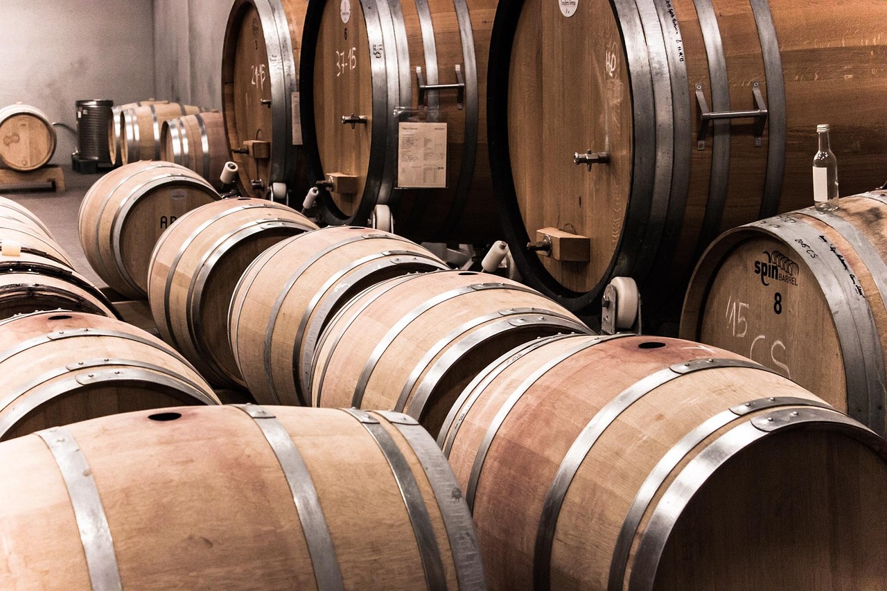 Rows of oak wine barrels lined up in a wine cellar