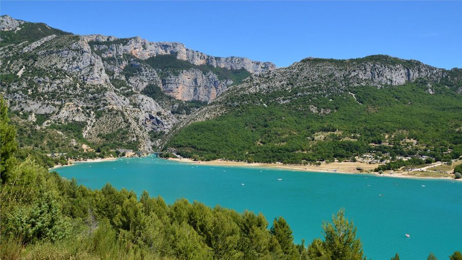 Aerial view of turquoise lake surrounded by green mountains near Aiguines France