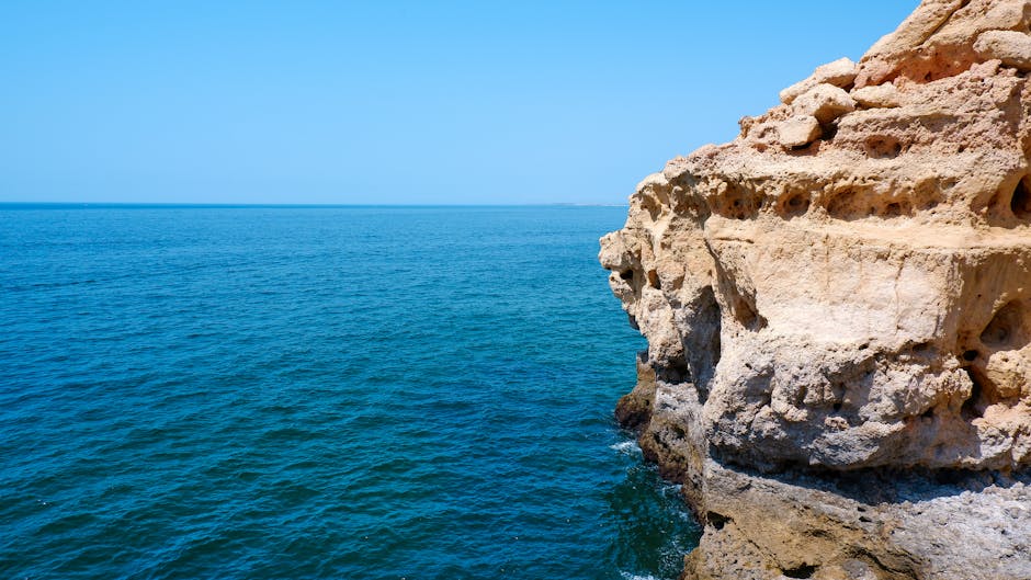 Golden cliffs with a small beach at the base in the Algarve