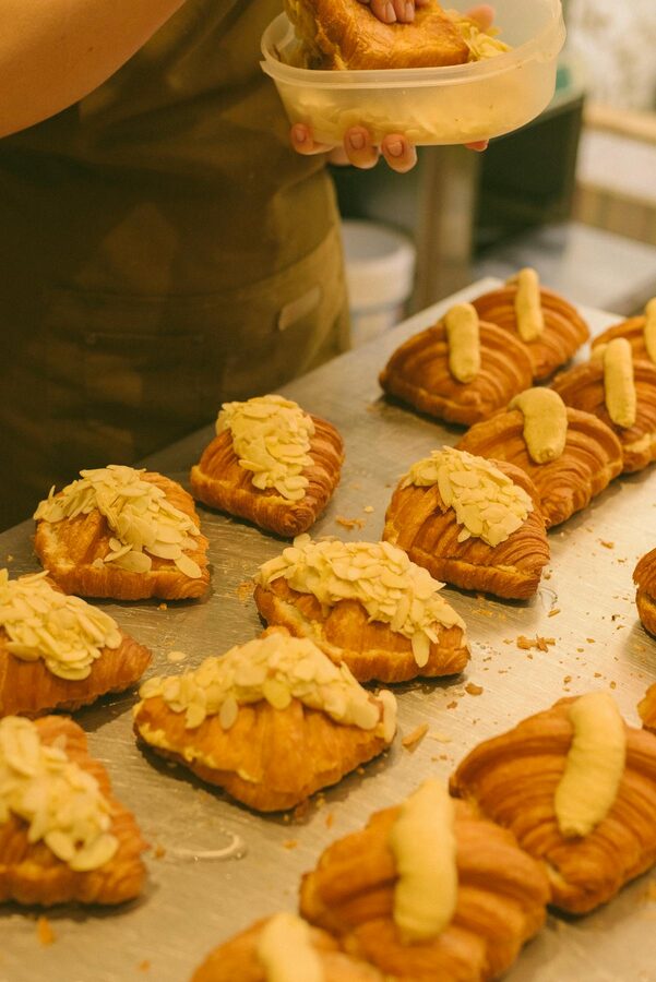 Bakery chef preparing fresh almond croissants