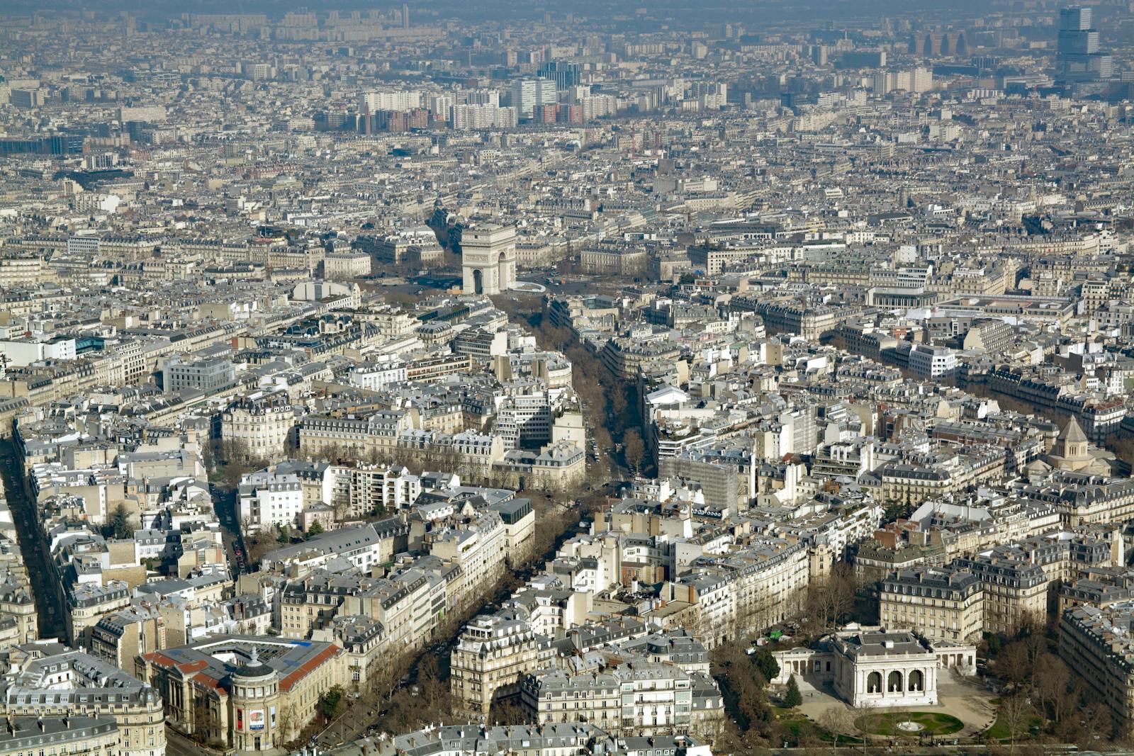 Breathtaking aerial view of Paris with the iconic Arc de Triomphe amidst the dense cityscape