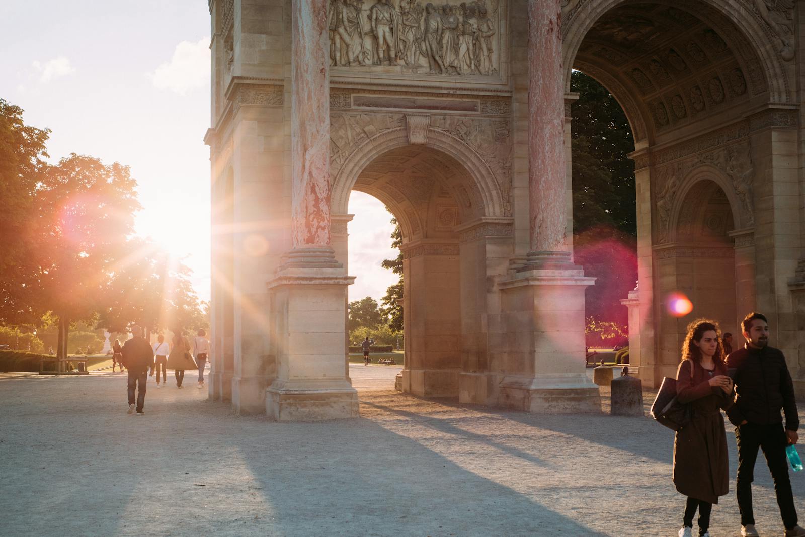 A romantic scene with sunrays shining through a Parisian archway