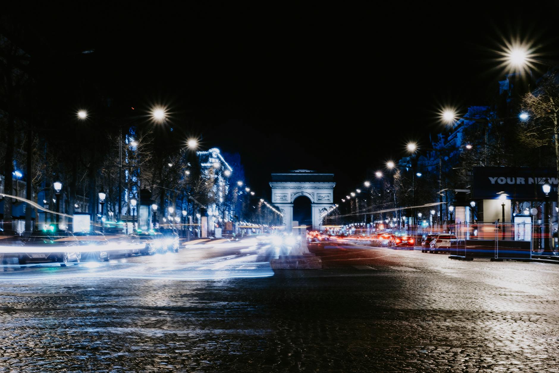 A long exposure night shot of the Arc de Triomphe on the Champs-Élysées