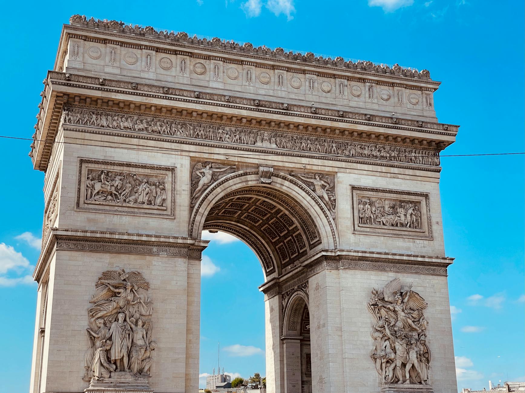 The magnificent Arc de Triomphe against a clear blue sky in Paris