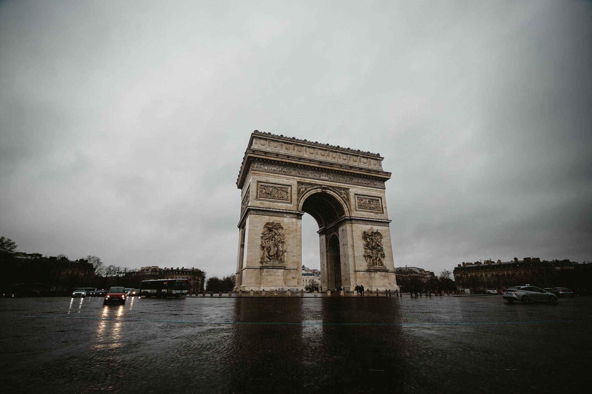 The Arc de Triomphe standing prominently under a cloudy sky