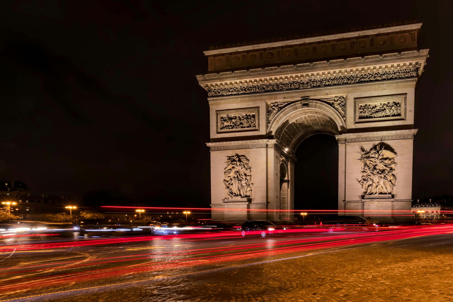 A long exposure capture of light trails around the Arc de Triomphe at night