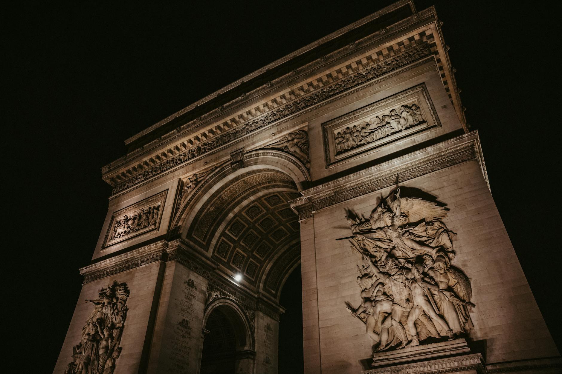 The Arc de Triomphe illuminated at night showcasing its neoclassical architecture