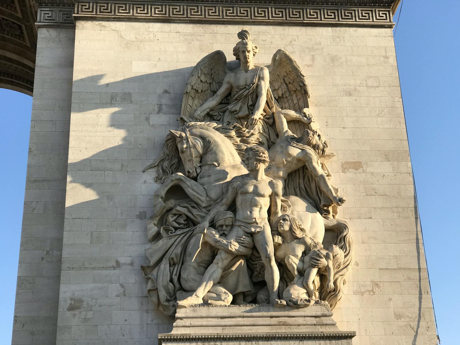Close-up of a detailed sculpture on the Arc de Triomphe in Paris with morning light