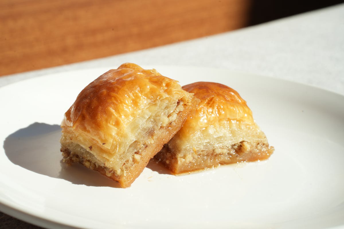 Two pieces of baklava on a white plate