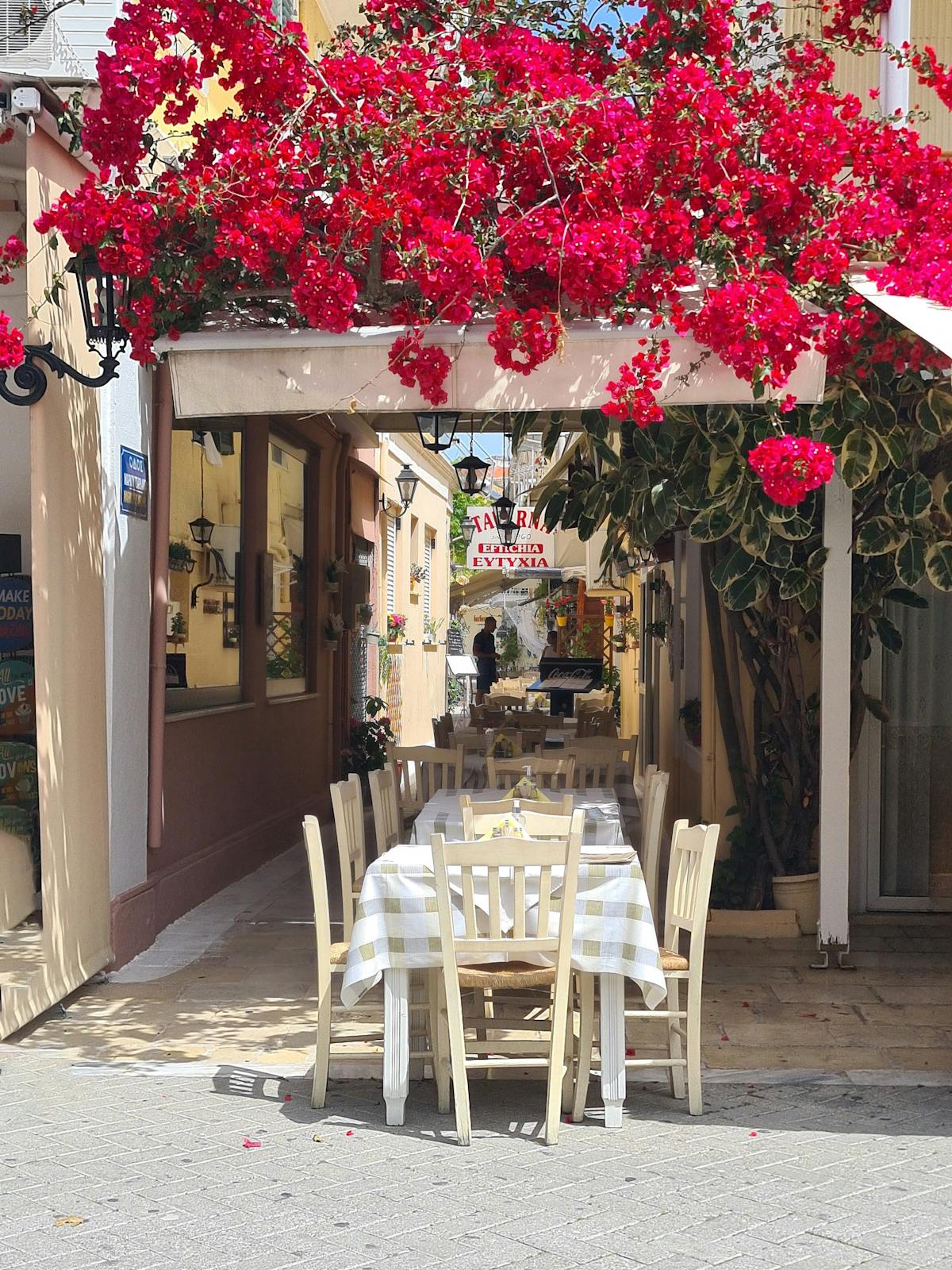 Dining under vibrant bougainvillea flowers at a Greek restaurant