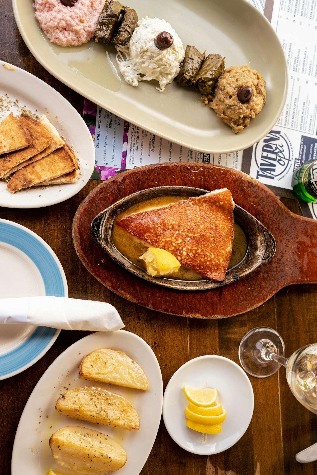 Greek mezze dishes including saganaki, pita, and dips on a table