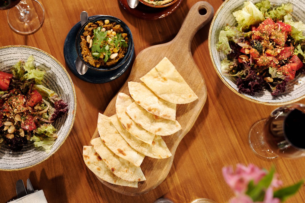 Mediterranean spread with pita, salads, and wine on a table