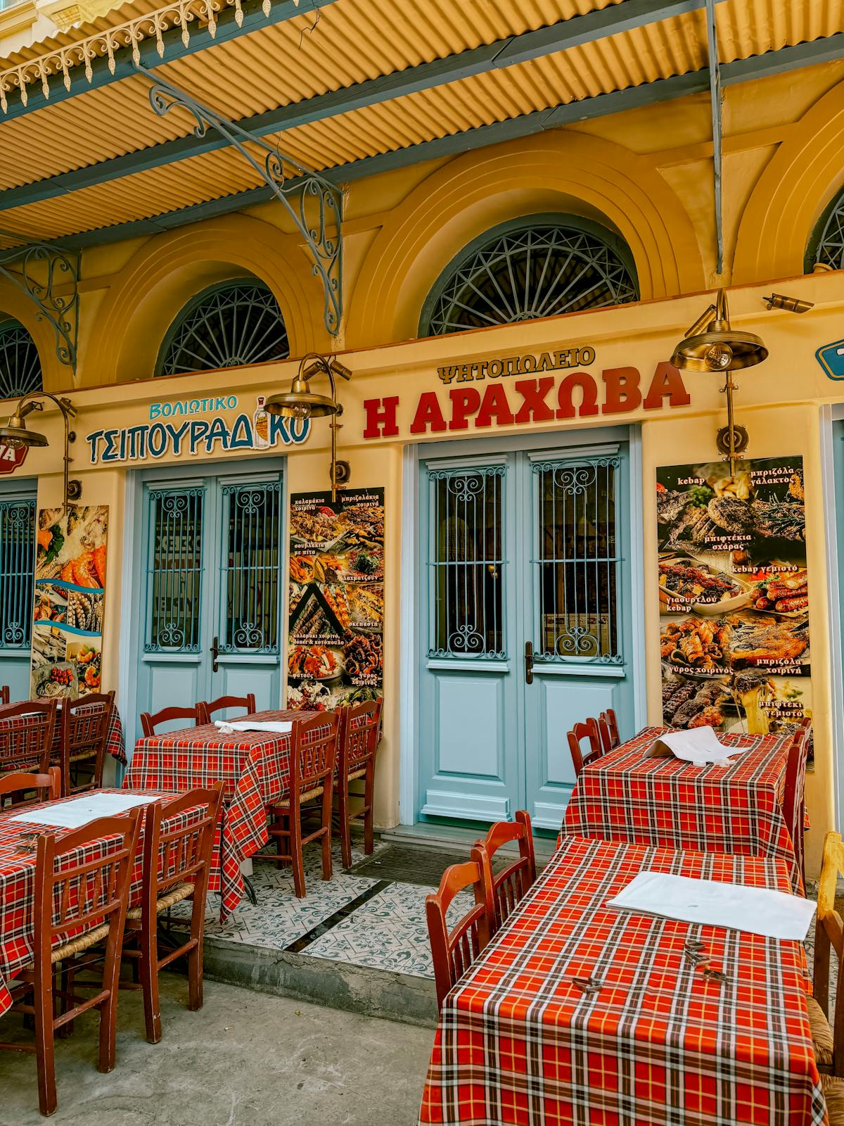Outdoor seating at a Greek restaurant in Athens with classic architecture