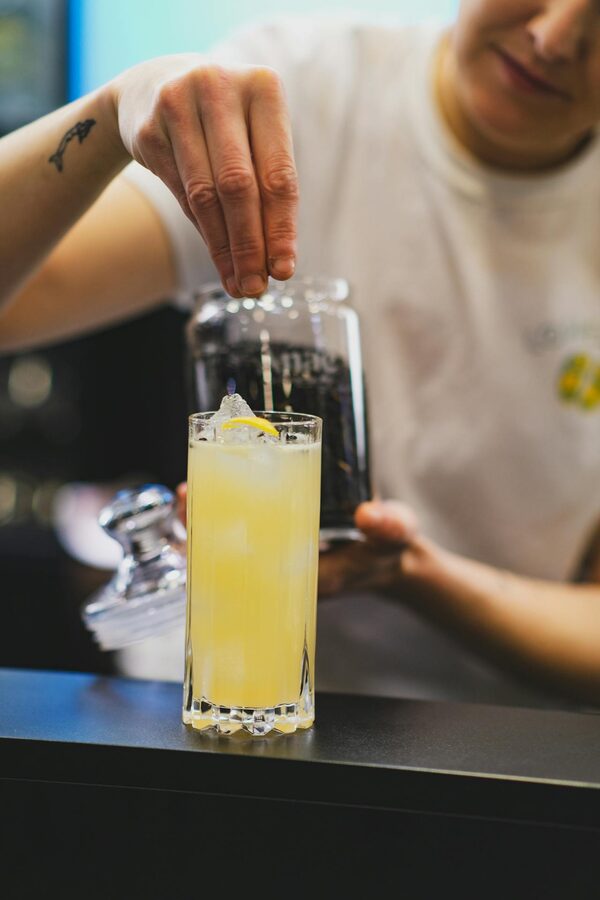 Bartender preparing lemonade cocktail with ice