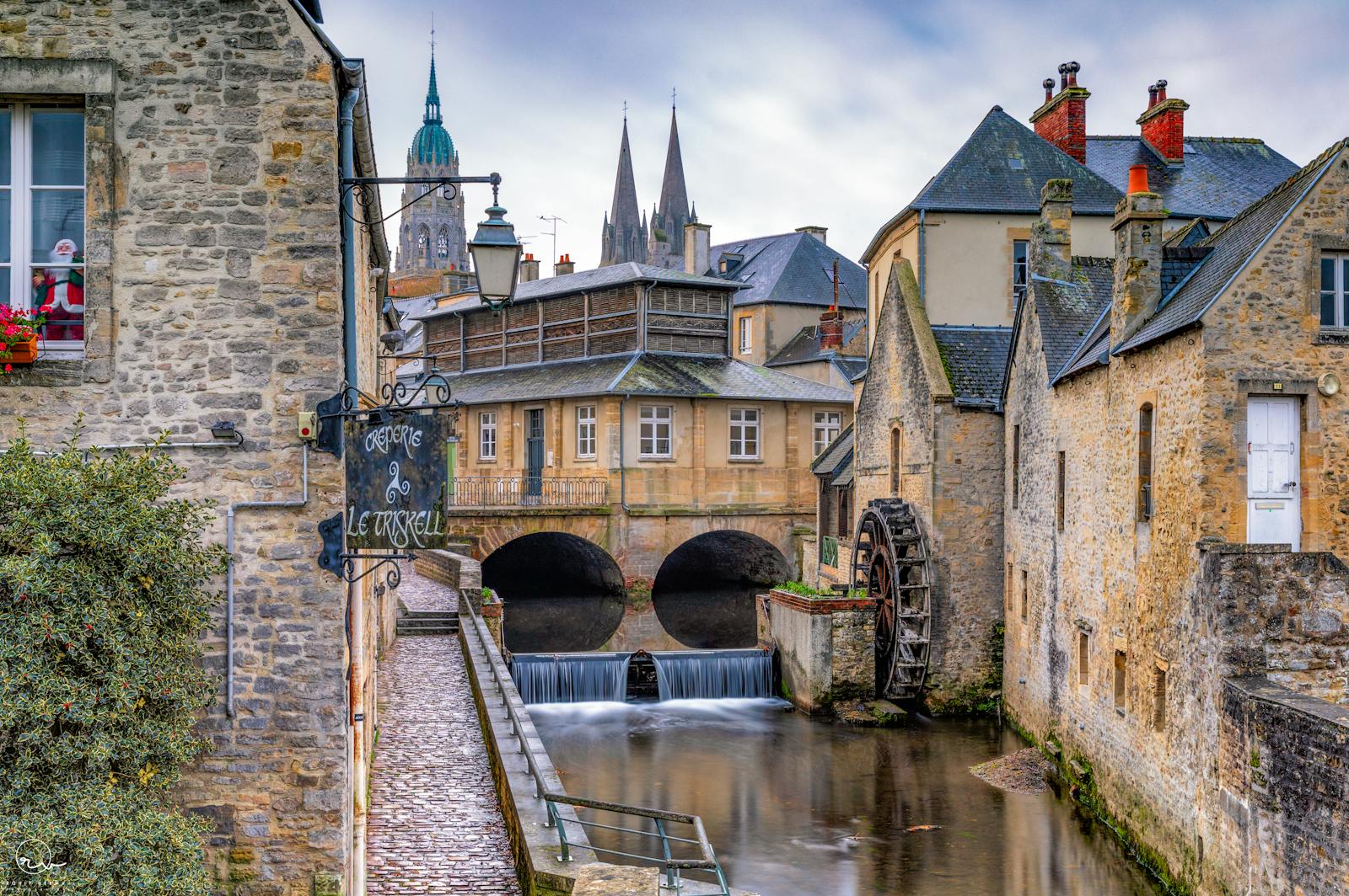 Historic watermill on a picturesque canal in Bayeux showcasing Normandy's charm