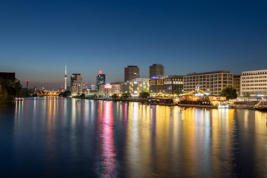 Illuminated Berlin cityscape reflecting on the Spree at night