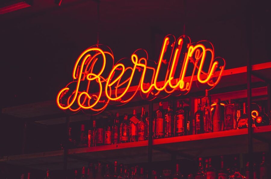 Illuminated Berlin neon sign above bar