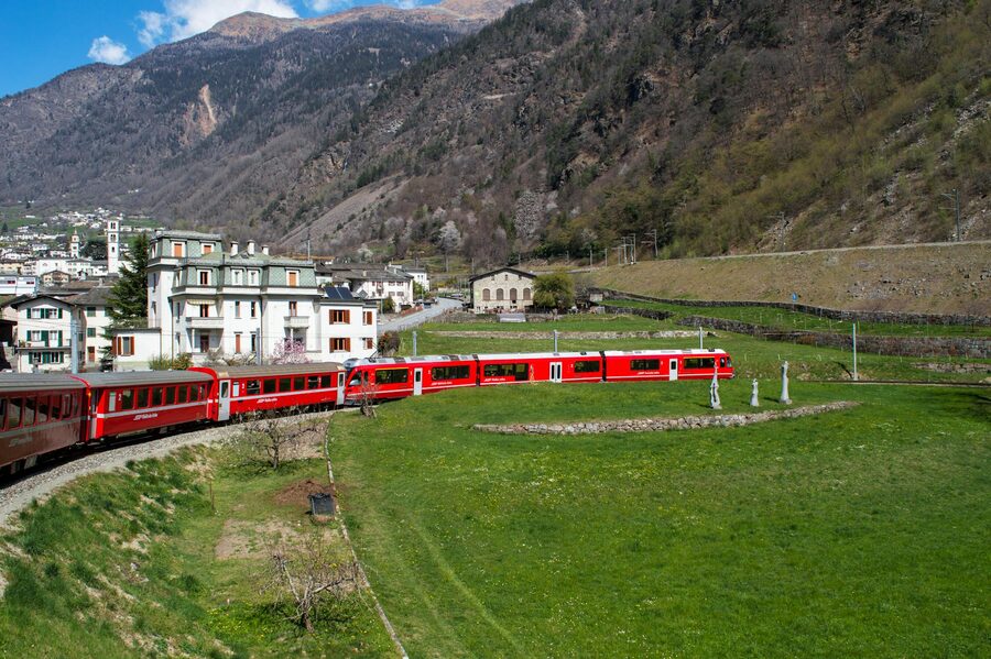 Bernina Express red train in scenic Swiss Alps valley