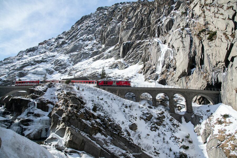Red train on snowy viaduct in Swiss Alps