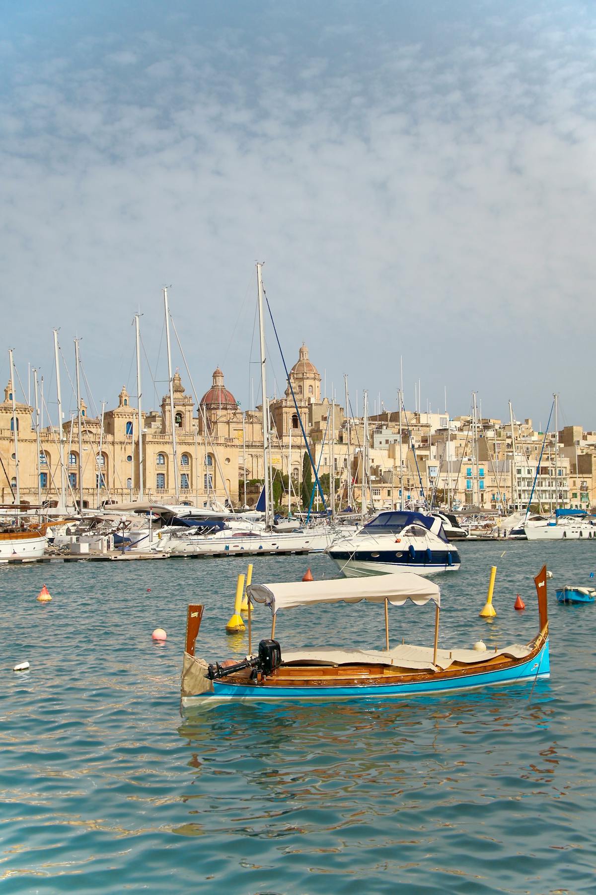 Boats in Birgu harbour with historic architecture in the background