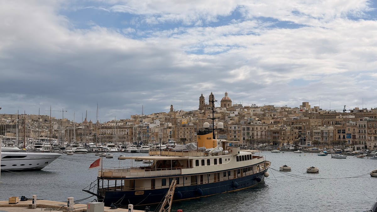 Classic boat moored at Vittoriosa Marina with historic buildings in the background