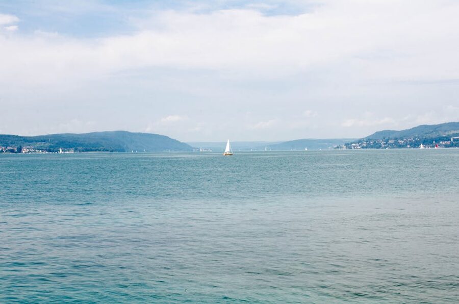 Sailboat on calm Lake Constance with mountains
