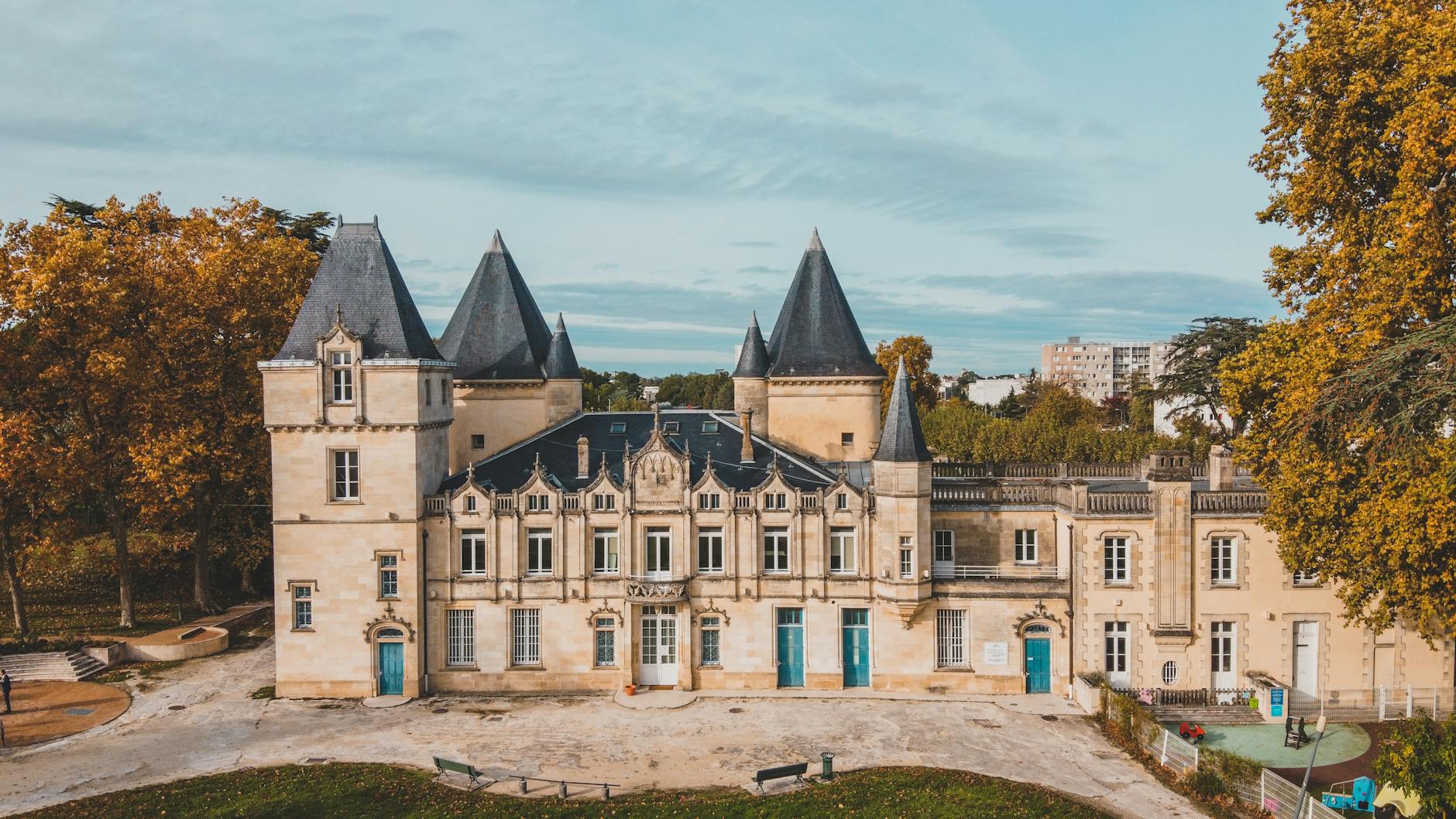 Aerial view of a Bordeaux chateau with autumn trees