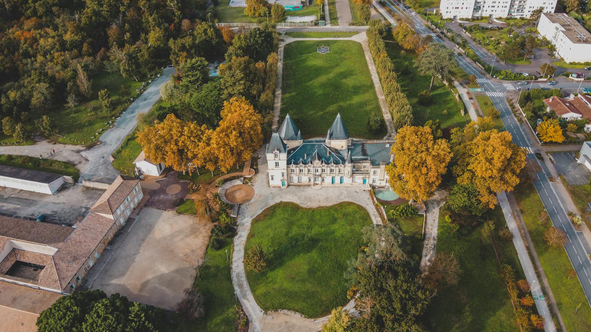 Aerial view of a chateau surrounded by greenery in Bordeaux