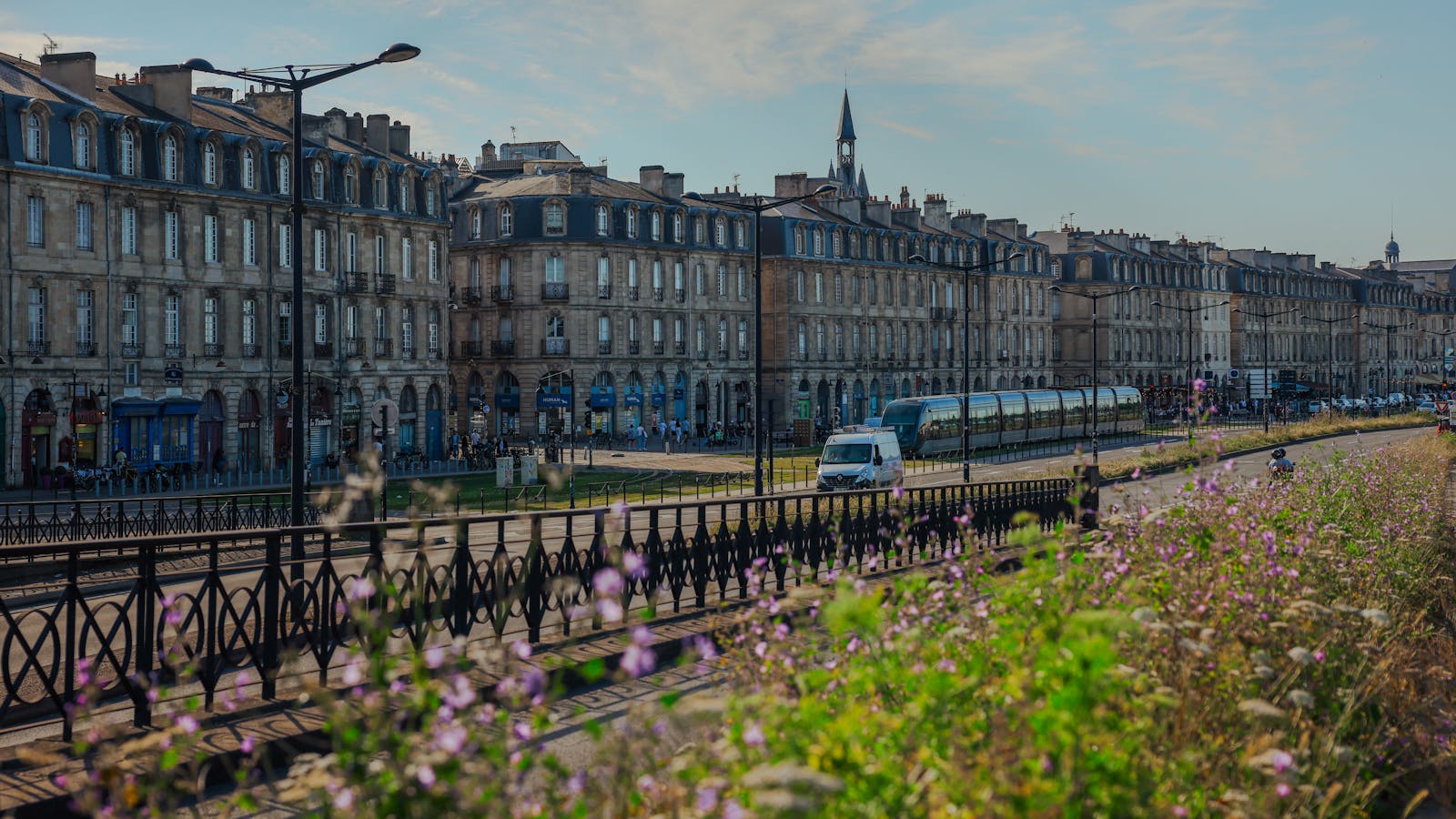 Historic buildings and tram in Bordeaux France with flowers in the foreground