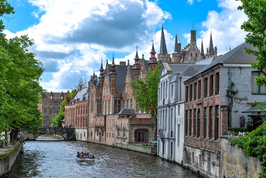 Canal scene in Bruges with tour boat on a sunny day