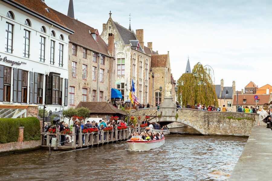 Bruges canals with historic buildings and a tourist-filled boat