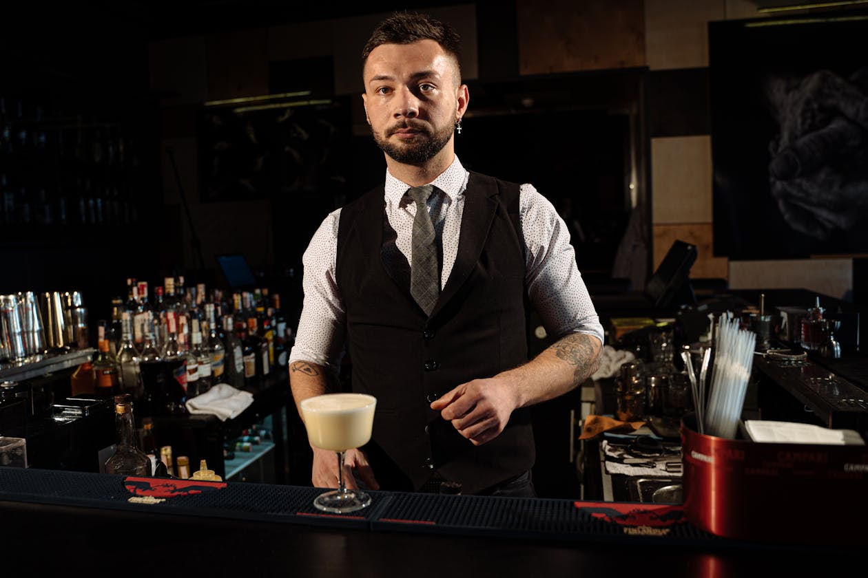 Professional bartender serving a creamy cocktail