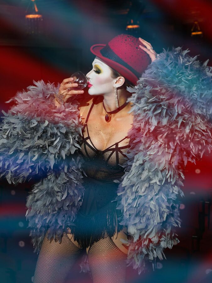 Cabaret performer in a feathered costume on stage