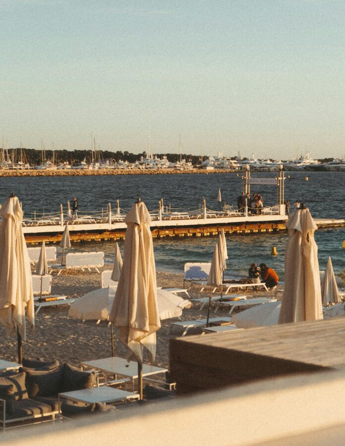Cannes beachfront with beach chairs umbrellas and marina