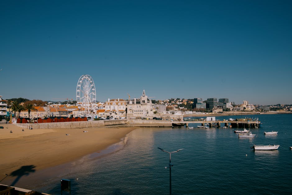 Boats moored in Cascais harbour with town in background