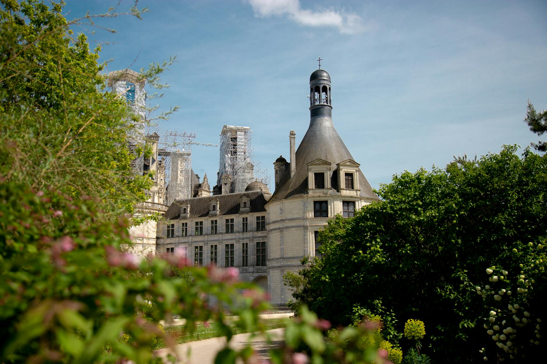 Ornate Chambord Castle surrounded by lush greenery and flowers